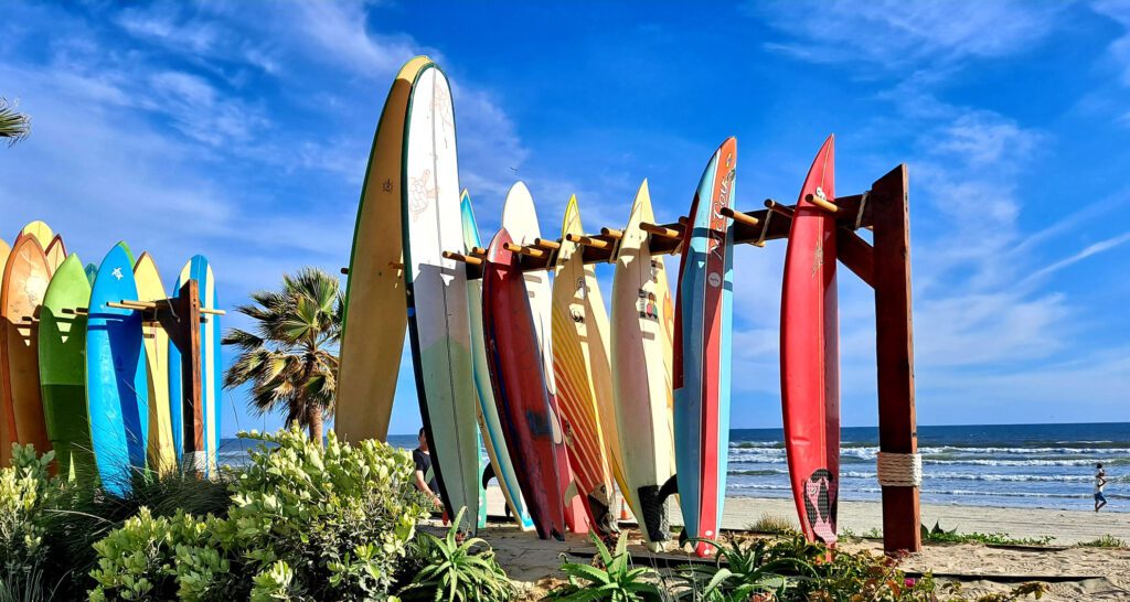 surfboards on a rack with blue sky in the background at coronado beach